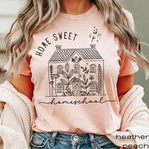 May include: A pink t-shirt with a black graphic of a house with the text "Home Sweet Homeschool" printed on it.