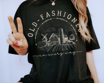 May include: Black t-shirt with a white graphic of a farmhouse, windmill, and the text "Old-Fashioned in every way".