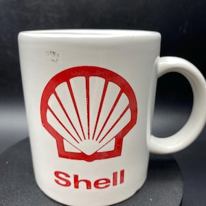 May include: White ceramic mug with a red Shell logo and the word "Shell" printed in red.