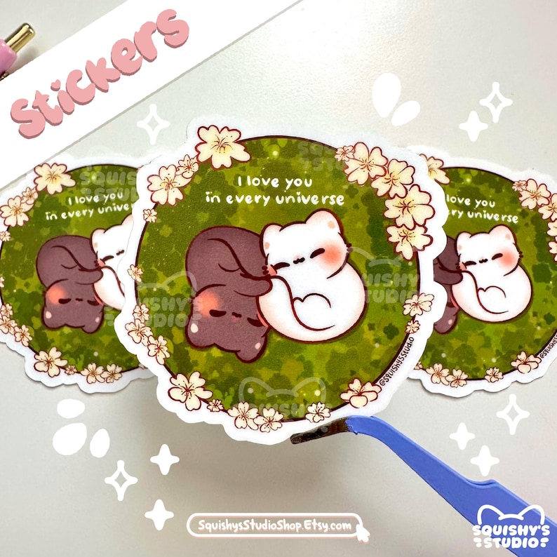 May include: A collection of stickers featuring a cute cartoon couple embracing. The stickers have a green background with white flowers and the text "I love you in every universe". The stickers are white and brown, with a heart-shaped design.