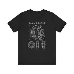 Peut inclure: Un t-shirt noir à manches courtes arborant un dessin technique blanc d'un roulement à billes. Le motif inclut le texte BALL BEARING, ainsi que des vues de face, de côté et en coupe A-A avec diverses lignes et étiquettes de dimensions.