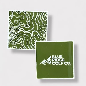 May include: Two square stickers. One features a white topographical map design on a green background. The other has the text "BLUE RIDGE GOLF CO." in white on a green background. Both stickers have white borders.