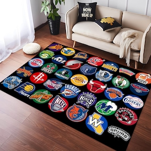 Pu&ograve; includere: Un tappeto nero e bianco con una variet&agrave; di loghi di squadre NBA in cerchi colorati. I loghi includono i Celtics, i Lakers, i Bulls, i Knicks e molti altri.