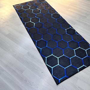 May include: A black and blue geometric patterned rug with a hexagonal design. The rug is made of a soft, durable material and is perfect for adding a modern touch to any room.
