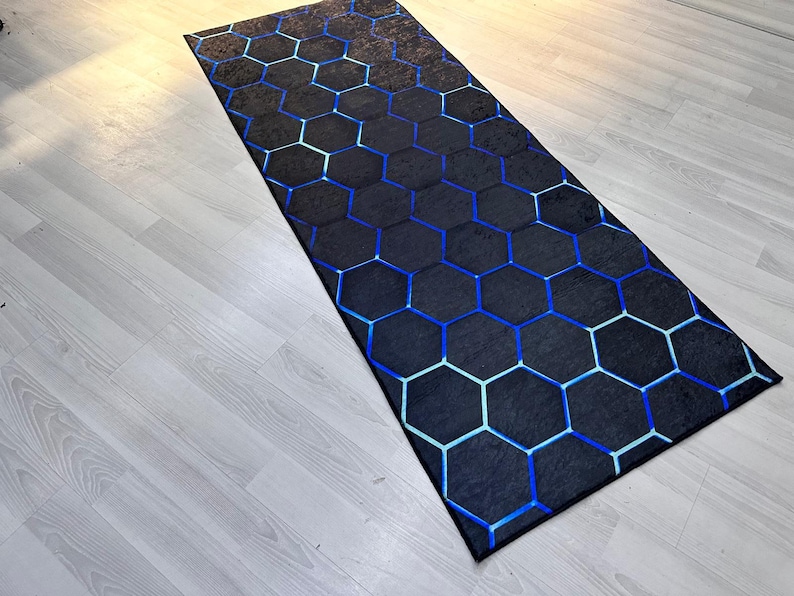 May include: A black and blue geometric patterned rug with a hexagonal design. The rug is made of a soft, durable material and is perfect for adding a modern touch to any room.