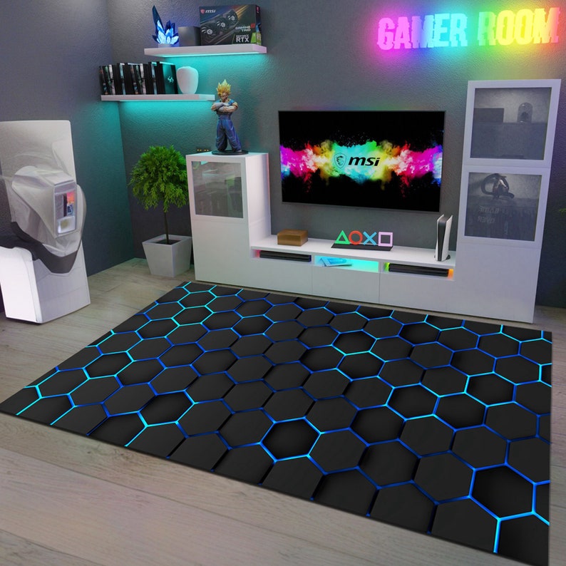 May include: A black and blue hexagonal patterned rug with a gamer room setup in the background. The setup includes a TV with the MSI logo, a white entertainment center, and a gaming console.