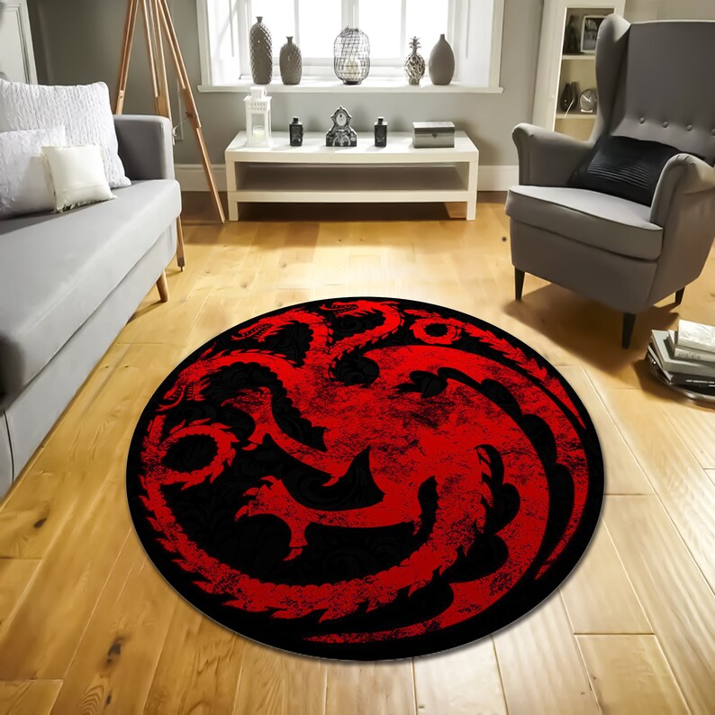 May include: A round red and black rug with a three-headed dragon design. The dragon is a symbol from the popular TV show Game of Thrones.