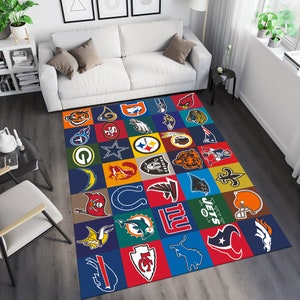 May include: A colorful rug with a patchwork design featuring logos of various NFL teams. The rug is made up of squares with different colored backgrounds and team logos in the center of each square. The rug is perfect for any football fan.