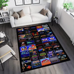 Może przedstawiać: Czarno-niebieski dywan z siatką retro tytułów gier wideo. Dywan zawiera tytuły takie jak "Sonic the Hedgehog", "Street Fighter", "Mortal Kombat" i "Super Mario Bros."