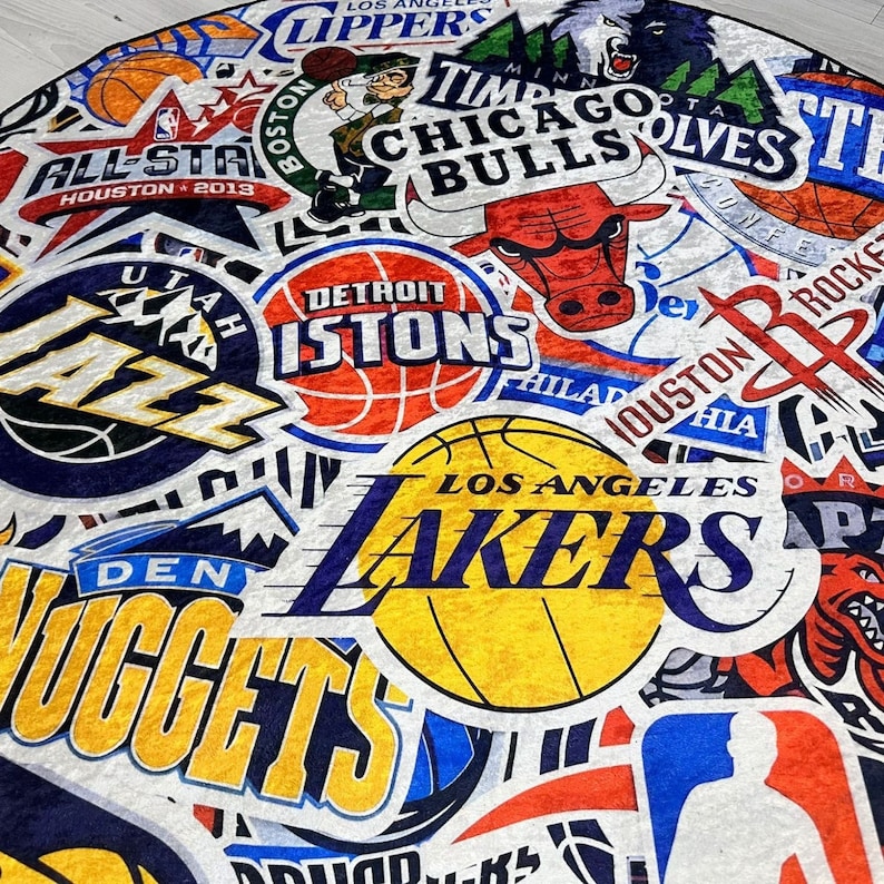May include: A colourful collage of NBA team logos, including the Utah Jazz, Detroit Pistons, Chicago Bulls, Los Angeles Lakers, Denver Nuggets, and Houston Rockets. The logos are arranged in a circular pattern on a white background.