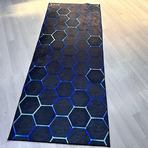 May include: A black and blue geometric patterned rug with a hexagonal design. The rug is made of a soft, plush material and is perfect for adding a touch of modern style to any room.