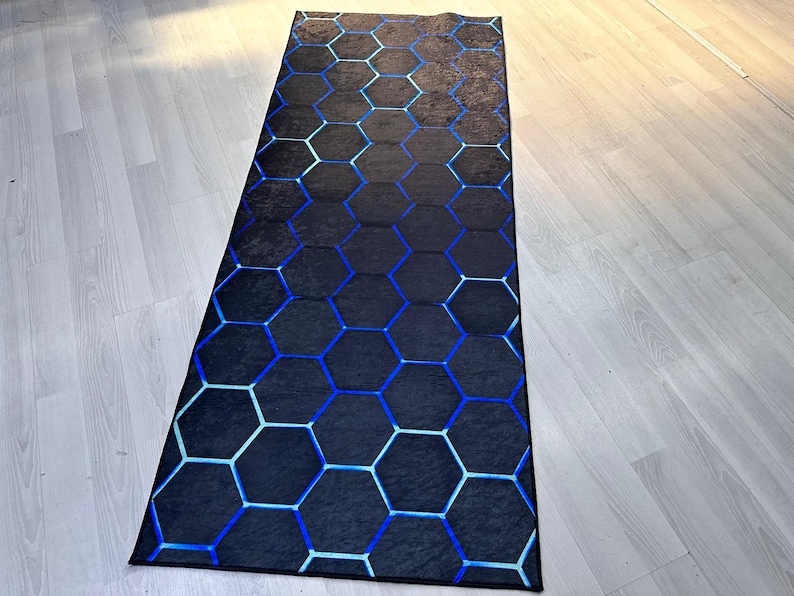 May include: A black and blue geometric patterned rug with a hexagonal design. The rug is made of a soft, plush material and is perfect for adding a touch of modern style to any room.