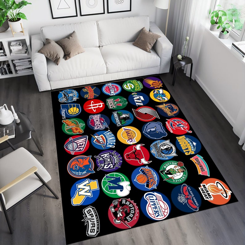 Pu&ograve; includere: Un tappeto nero e bianco con un motivo colorato di loghi delle squadre NBA. I loghi sono disposti in un cerchio e includono squadre come i Lakers, i Celtics e i Knicks.