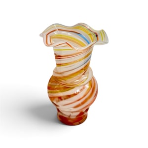 May include: A glass vase featuring a bulbous base and a ruffled, flared rim. The surface is decorated with swirling, horizontal stripes in shades of orange, yellow, blue, and white, creating a multi-colored, translucent, and layered appearance.