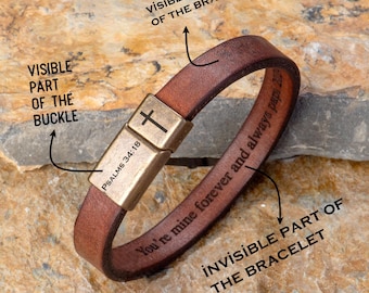 May include: Brown leather bracelet with a gold-colored clasp. The clasp features a cross and the text "PSALMS 34:18". The bracelet is engraved with the words "You're mine forever and always papi 20".