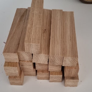 May include: A stack of wooden dowels, probably for crafting or woodworking projects. The dowels are light brown and have a smooth, polished finish.