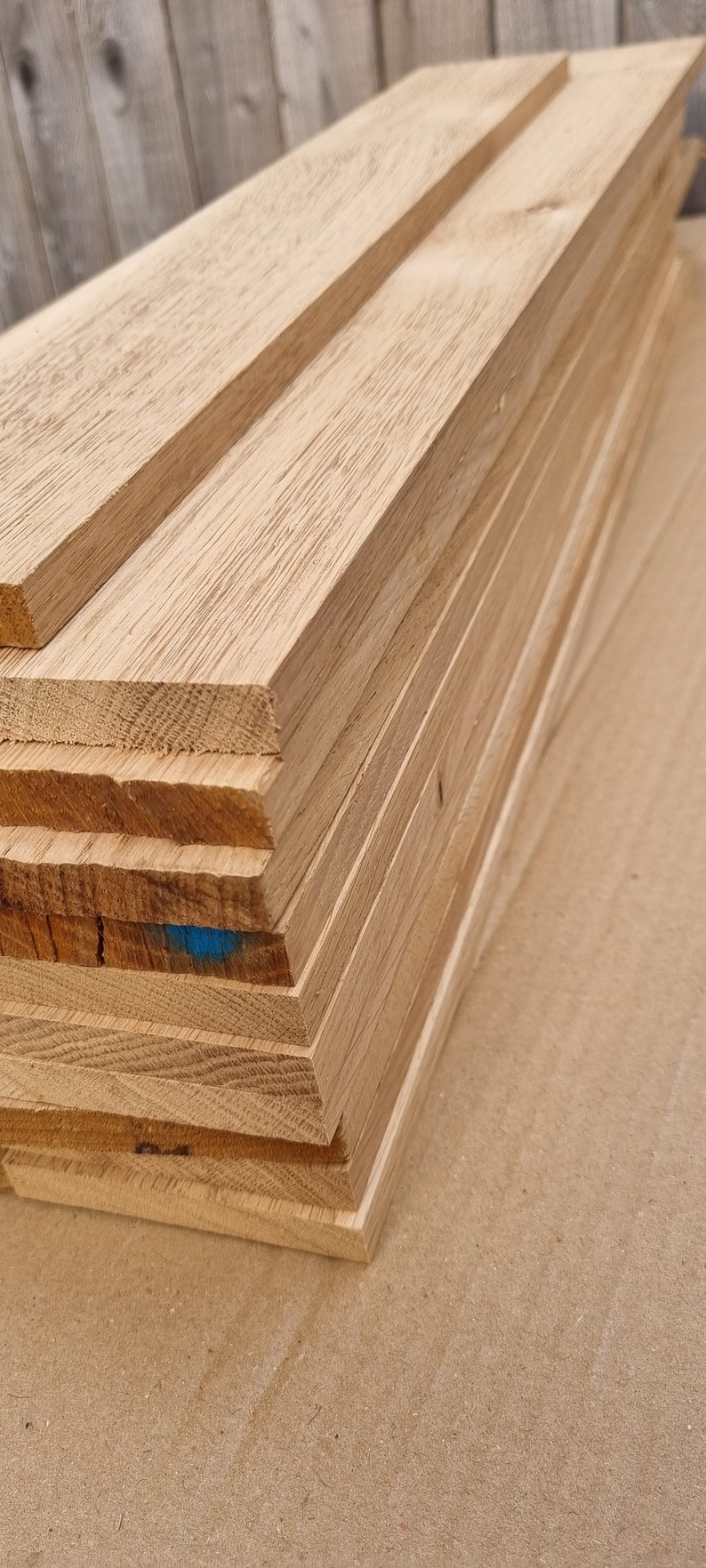 May include: A stack of unfinished, light brown wooden boards. The boards are stacked neatly and are ready to be used for a variety of woodworking projects.