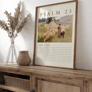 May include: A framed print of Psalm 23, a Psalm of David, with a vintage illustration of a shepherdess with a flock of sheep in a green pasture. The text is in a brown font on a cream background.