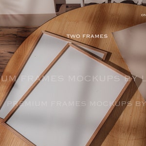 May include: Two wooden picture frames with white mounts on a wooden table. The frames are empty and ready for your photos. The text "TWO FRAMES" is visible in the image. The text "PREMIUM FRAMES MOCKUPS BY LUIFRS" is visible in the image.