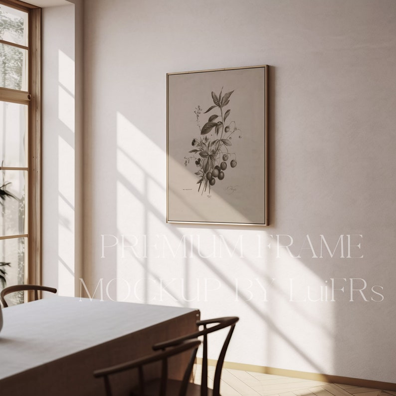 May include: A framed black and white botanical print of a flowering plant with berries hanging from the branches. The print is hanging on a white wall in a room with a wooden table and chairs.