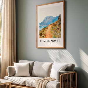 Peut inclure: Une impression encadr&eacute;e d'une peinture de Claude Monet intitul&eacute;e "La Corniche pr&egrave;s de Menton" repr&eacute;sentant un chemin sinueux menant &agrave; un flanc de montagne avec une mer bleue en arri&egrave;re-plan.
