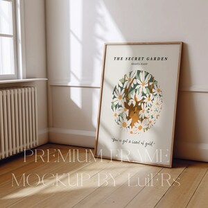 Op de afbeelding: Een ingelijste print met een lichtgroene achtergrond en een cirkel van witte bloemen met een hert in het midden. De tekst "THE SECRET GARDEN" en "SHASTA DAISY" staat bovenaan de print. De tekst "You've got a heart of gold." staat onderaan de print.