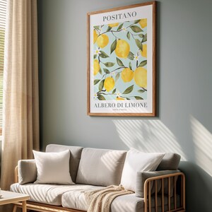 Peut inclure: Une impression encadr&eacute;e d'une peinture &agrave; l'aquarelle d'un citronnier avec le texte "Positano, Albero di Limone, Costa d'Amalfi". L'arri&egrave;re-plan est de couleur bleu clair et les citrons sont jaunes.