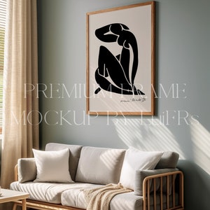 Peut inclure: Une estampe encadr&eacute;e en noir et blanc d'une femme assise la t&ecirc;te baiss&eacute;e. L'estampe est dans un cadre en bois clair et est accroch&eacute;e &agrave; un mur bleu clair. L'estampe est intitul&eacute;e "Henri Matisse".