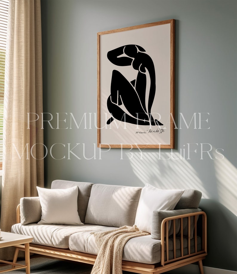 Peut inclure: Une estampe encadr&eacute;e en noir et blanc d'une femme assise la t&ecirc;te baiss&eacute;e. L'estampe est dans un cadre en bois clair et est accroch&eacute;e &agrave; un mur bleu clair. L'estampe est intitul&eacute;e "Henri Matisse".