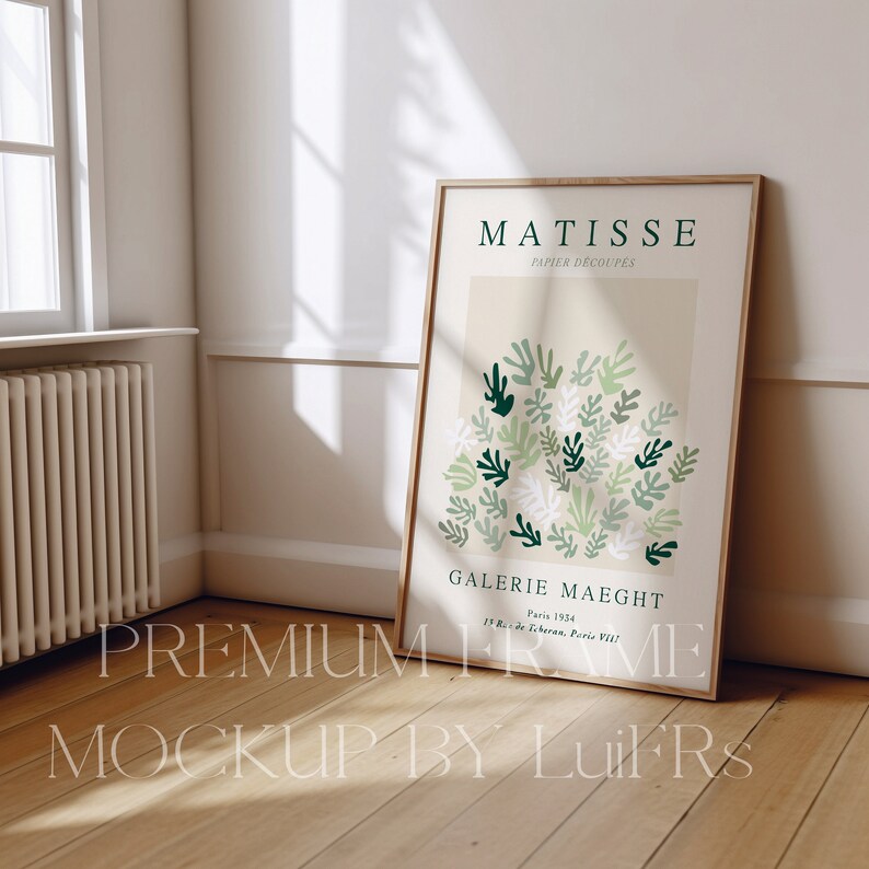 Op de afbeelding: Een ingelijste poster met een abstract ontwerp in groen, wit en beige. De poster is getiteld "MATISSE PAPIER DECOUPES" en bevat de tekst "GALERIE MAEGHT Paris 1954 15 Rue de Teheran, Paris VIII!"