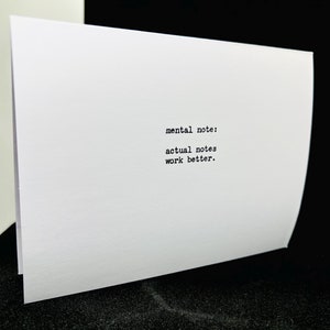 May include: White card with black text that reads "mental note: actual notes work better."