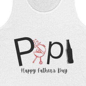 May include: White tank top with black text that reads "Pop!" with a red grill and a black bottle. The text "Happy Father's Day" is below the main text.