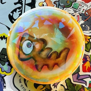 Pin holográfico de huevo dorado de Splatoon con la carrera del salmón