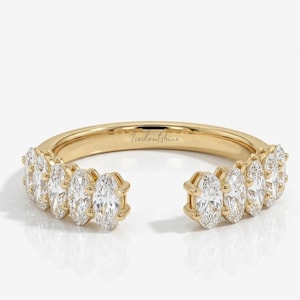 May include: Open-style gold ring with multiple oval-cut clear gemstones. The ring has a split design, with gemstones set along the top band. The text "Icedoutshine" is engraved on the ring's band.