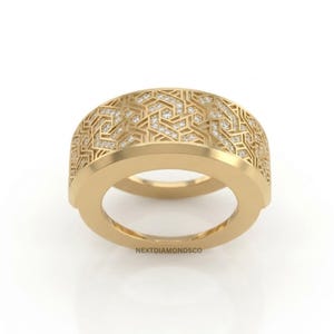 May include: A wide gold band ring featuring an intricate geometric lattice pattern across the outer surface, embedded with small sparkling diamonds. The text NEXTDIAMONDSCO is printed in small black letters at the base of the ring.