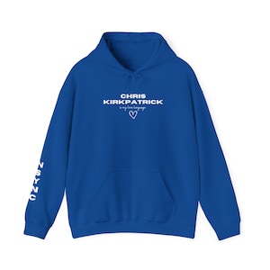 May include: Royal blue hoodie with white text that reads "CHRIS KIRKPATRICK is my love language" with a heart symbol. The left sleeve has the word "NSYNC" written vertically in white.