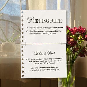 May include: A white paper with the title "PRINTING GUIDE" and instructions for printing a custom newspaper. The paper is perforated along the left edge and includes text about PDF print and template size. A bouquet of red flowers is in a glass vase.