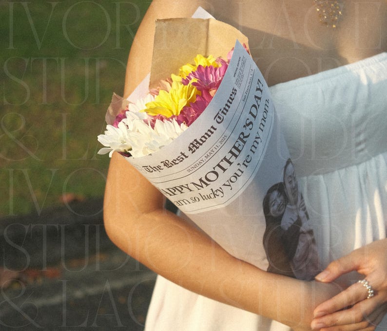 May include: A bouquet of colorful flowers wrapped in newspaper. The newspaper reads "Happy Mother's Day!" and features a photo. The bouquet includes white, yellow, and pink flowers.