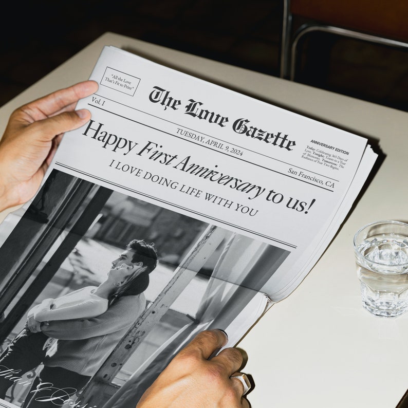 May include: A black and white photo of a couple in a newspaper with the headline "Happy First Anniversary to us! I LOVE DOING LIFE WITH YOU". The newspaper is titled "The Love Gazette" and is dated Tuesday, April 9, 2024.