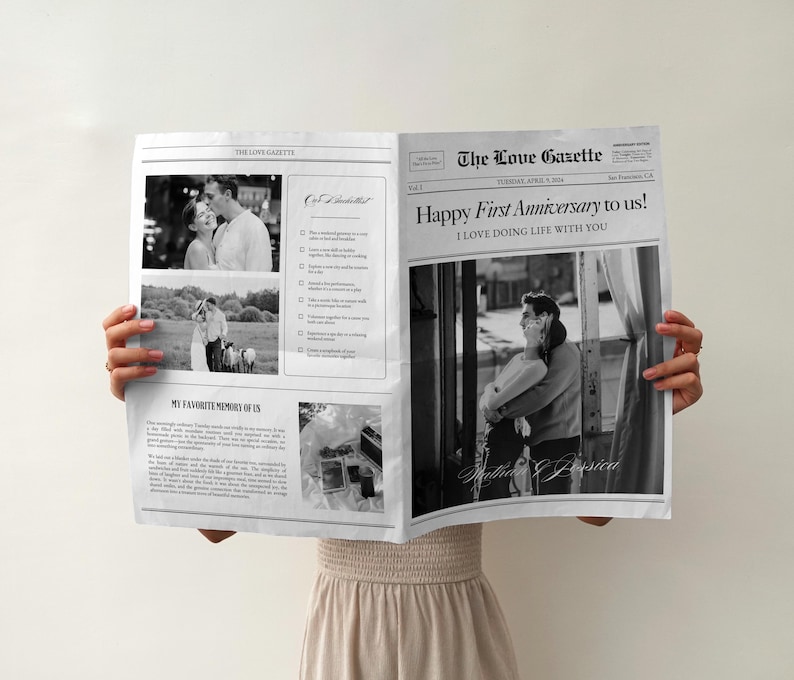 May include: A black and white newspaper with the headline "The Love Gazette" and the text "Happy First Anniversary to us! I LOVE DOING LIFE WITH YOU". The newspaper features photos of a couple.