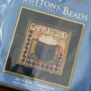 Könnte beinhalten: Ein Kreuzstich-Set mit einem Cappuccino-Design aus der Herbstserie. Die Designgröße beträgt 12,7 cm x 12,7 cm. Das Bild zeigt eine blaue Tasse mit einem Herz, bedeckt mit Schlagsahne, und dem Wort "CAPPUCCINO".