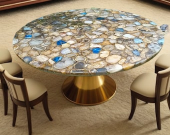 May include: A round dining table with a unique agate stone top featuring a mix of brown, gray, and blue tones. The table has a gold metal base and is surrounded by four chairs.