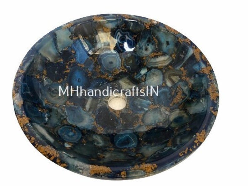 May include: A round blue agate stone sink with gold accents. The sink is made of natural stone and has a unique, organic pattern.