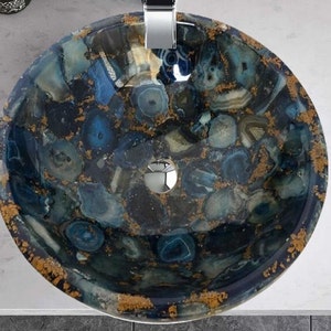 May include: A round, blue and gold agate sink with a drain in the center. The sink is made of a composite material that looks like natural stone.