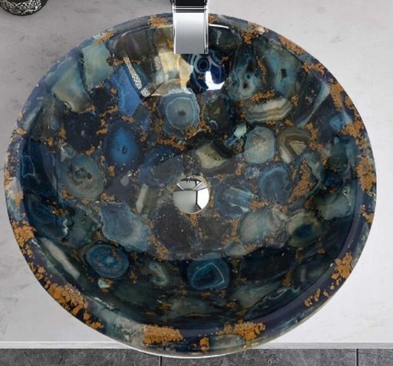 May include: A round, blue and gold agate sink with a drain in the center. The sink is made of a composite material that looks like natural stone.