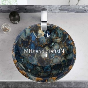 May include: A round, blue and gold agate sink with a white background. The sink has a unique, natural pattern and is perfect for a modern bathroom.