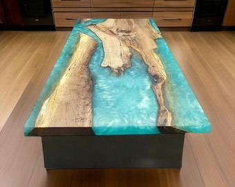 May include: A rectangular wooden coffee table with a turquoise epoxy resin river design. The table features natural wood grain and a dark base. The epoxy resin creates a flowing, water-like effect, adding a modern touch to the rustic wood.