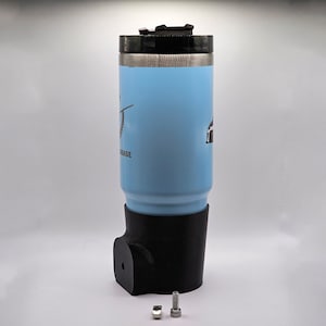 Könnte beinhalten: Hellblauer isolierter Becher mit schwarzem Deckel und Boden. Der Becher hat ein Logo und wird mit einer Schraube und einer Mutter geliefert. Er ist für Getränke konzipiert und hält die Temperatur. Höhe ca. 17 cm.