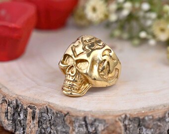 Peut inclure: Une bague en or en forme de crâne avec des détails complexes et une surface texturée.