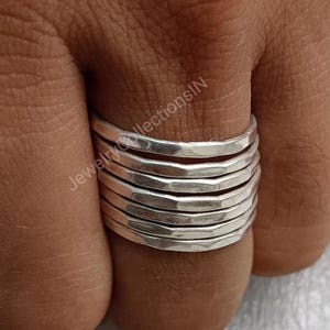 Peut inclure: Une bague en argent composée de plusieurs fines bandes empilées les unes sur les autres. Les bandes sont martelées et ont une finition texturée.
